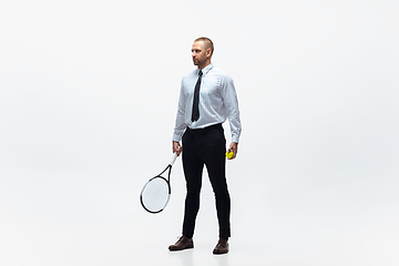 Image showing Time for movement. Man in office clothes plays tennis isolated on white studio background.