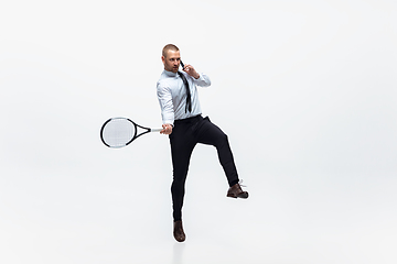 Image showing Time for movement. Man in office clothes plays tennis isolated on white studio background.