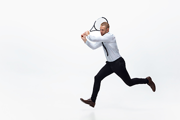 Image showing Time for movement. Man in office clothes plays tennis isolated on white studio background.