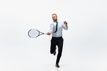 Image showing Time for movement. Man in office clothes plays tennis isolated on white studio background.