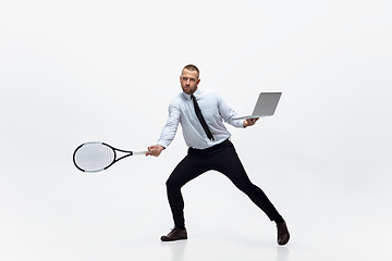 Image showing Time for movement. Man in office clothes plays tennis isolated on white studio background.