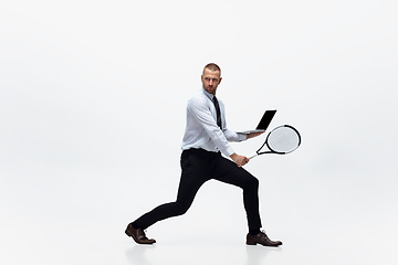 Image showing Time for movement. Man in office clothes plays tennis isolated on white studio background.