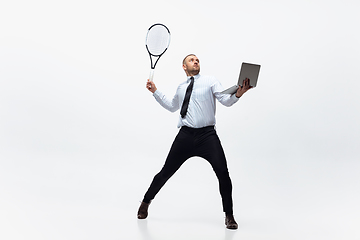 Image showing Time for movement. Man in office clothes plays tennis isolated on white studio background.