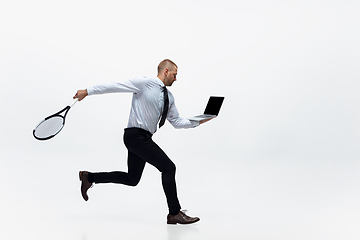 Image showing Time for movement. Man in office clothes plays tennis isolated on white studio background.