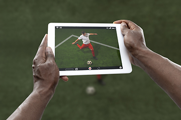 Image showing Close up hands holding tablet viewing sport, online translation, streaming of championship