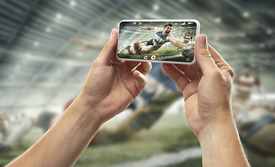 Image showing Close up hands holding smartphone viewing sport, online translation, streaming of championship