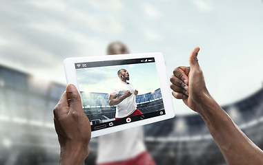 Image showing Close up hands holding tablet viewing sport, online translation, streaming of championship