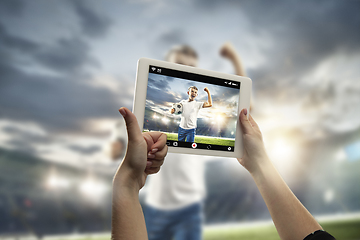 Image showing Close up hands holding tablet viewing sport, online translation, streaming of championship