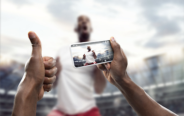 Image showing Close up hands holding smartphone viewing sport, online translation, streaming of championship