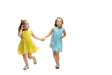 Image showing Happy little caucasian girls jumping and running isolated on white background