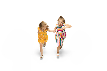 Image showing Happy little caucasian girls jumping and running isolated on white background