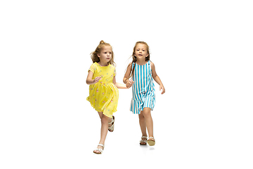 Image showing Happy little caucasian girls jumping and running isolated on white background