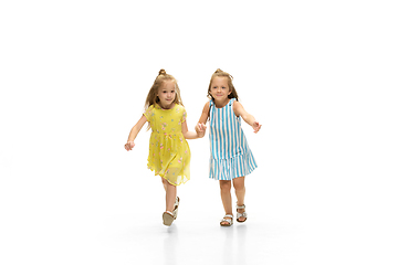 Image showing Happy little caucasian girls jumping and running isolated on white background