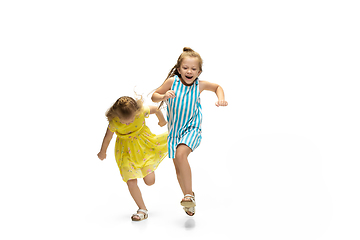 Image showing Happy little caucasian girls jumping and running isolated on white background