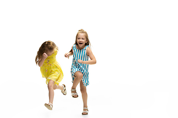 Image showing Happy little caucasian girls jumping and running isolated on white background