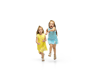 Image showing Happy little caucasian girls jumping and running isolated on white background