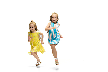 Image showing Happy little caucasian girls jumping and running isolated on white background