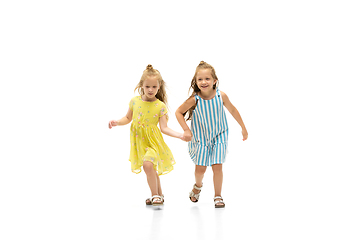 Image showing Happy little caucasian girls jumping and running isolated on white background