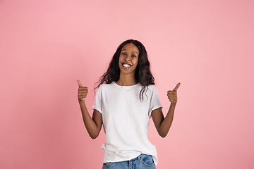 Image showing Cheerful african-american young woman isolated on pink background, emotional and expressive