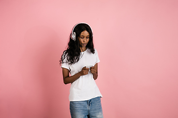 Image showing Cheerful african-american young woman isolated on pink background, emotional and expressive