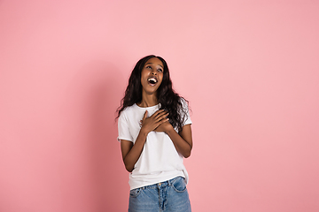 Image showing Cheerful african-american young woman isolated on pink background, emotional and expressive