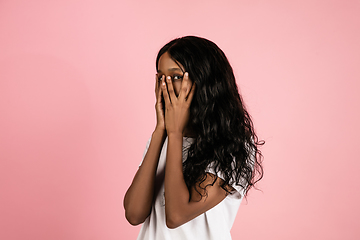 Image showing Cheerful african-american young woman isolated on pink background, emotional and expressive