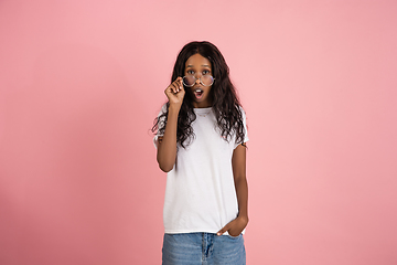 Image showing Cheerful african-american young woman isolated on pink background, emotional and expressive