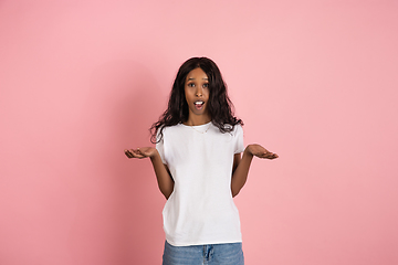 Image showing Cheerful african-american young woman isolated on pink background, emotional and expressive