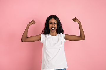 Image showing Cheerful african-american young woman isolated on pink background, emotional and expressive