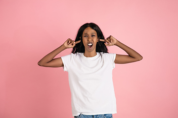 Image showing Cheerful african-american young woman isolated on pink background, emotional and expressive