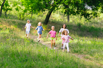 Image showing Kids, children running on meadow in summer\'s sunlight