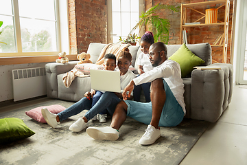 Image showing Young african family during quarantine, insulation spending time together at home