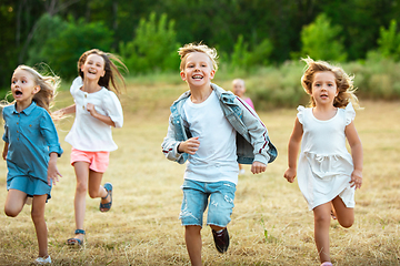 Image showing Kids, children running on meadow in summer\'s sunlight