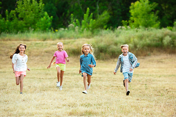 Image showing Kids, children running on meadow in summer\'s sunlight