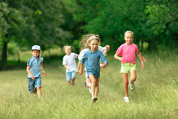 Image showing Kids, children running on meadow in summer\'s sunlight