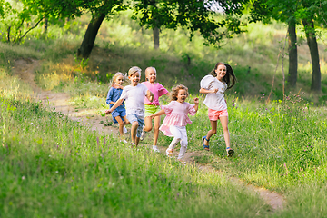 Image showing Kids, children running on meadow in summer\'s sunlight