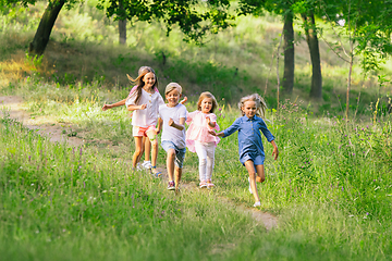 Image showing Kids, children running on meadow in summer\'s sunlight