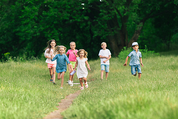 Image showing Kids, children running on meadow in summer\'s sunlight