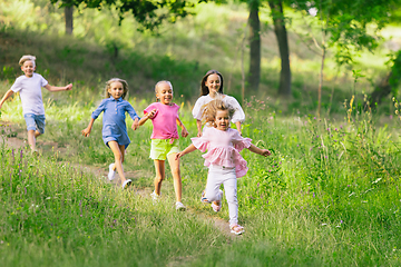 Image showing Kids, children running on meadow in summer\'s sunlight