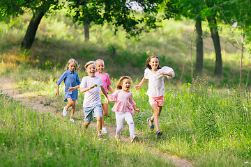 Image showing Kids, children running on meadow in summer\'s sunlight