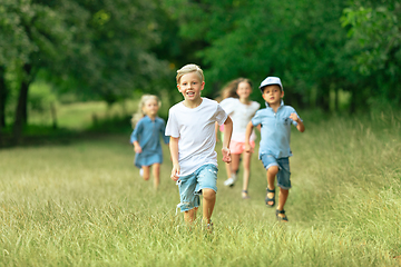 Image showing Kids, children running on meadow in summer\'s sunlight