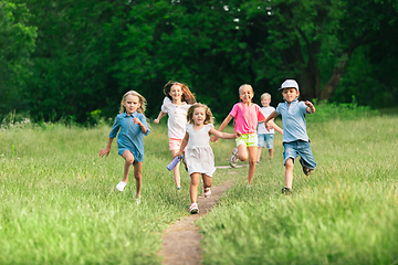 Image showing Kids, children running on meadow in summer\'s sunlight