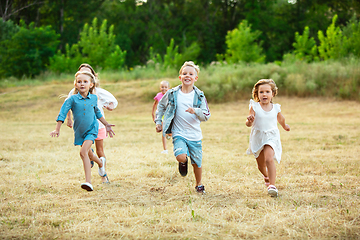 Image showing Kids, children running on meadow in summer\'s sunlight