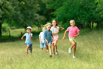 Image showing Kids, children running on meadow in summer\'s sunlight