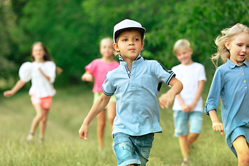 Image showing Kids, children running on meadow in summer\'s sunlight