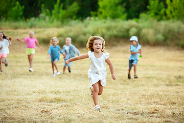 Image showing Kids, children running on meadow in summer\'s sunlight