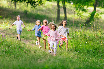 Image showing Kids, children running on meadow in summer\'s sunlight