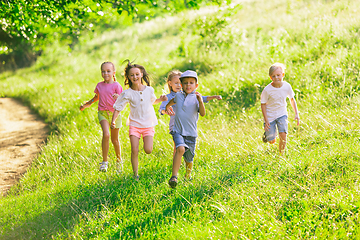 Image showing Kids, children running on meadow in summer\'s sunlight