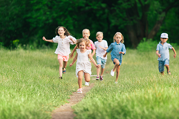 Image showing Kids, children running on meadow in summer\'s sunlight