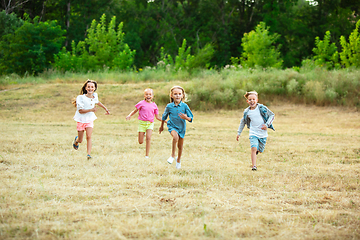 Image showing Kids, children running on meadow in summer\'s sunlight